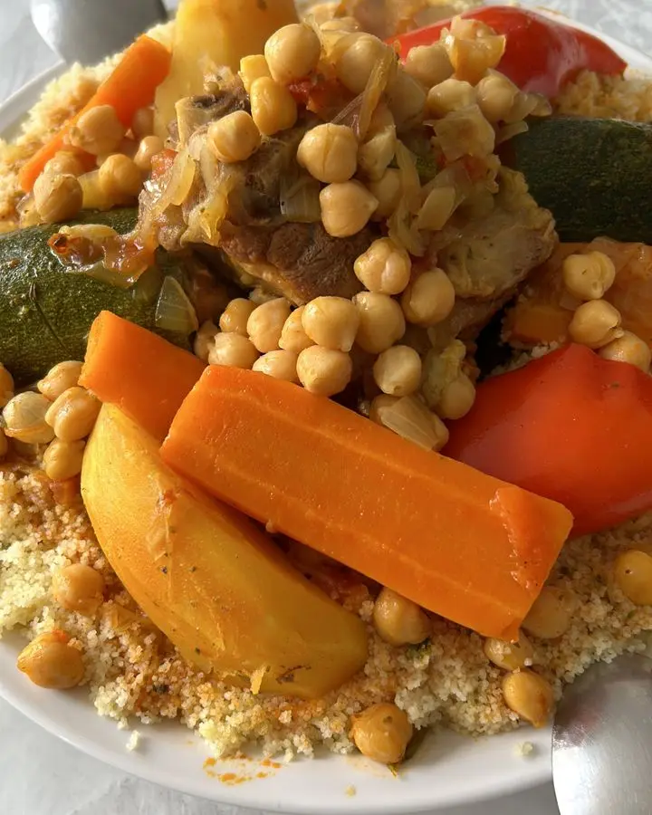 A vibrant dish of Moroccan couscous served with vegetables, chickpeas, and meat.