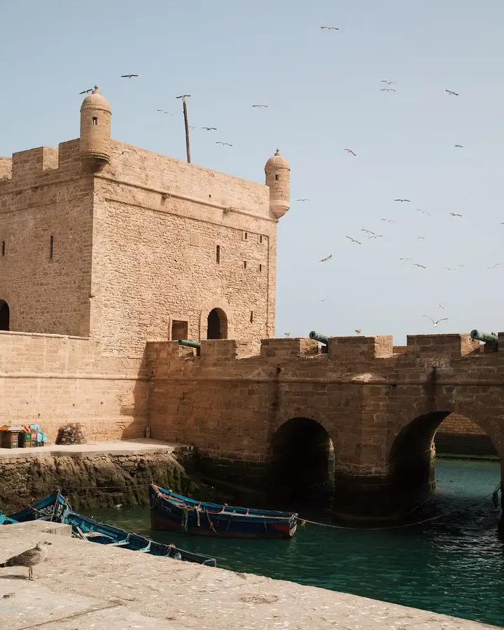 Scenic view of the old fort and blue fishing boats in Essaouira, Morocco's coastal city.