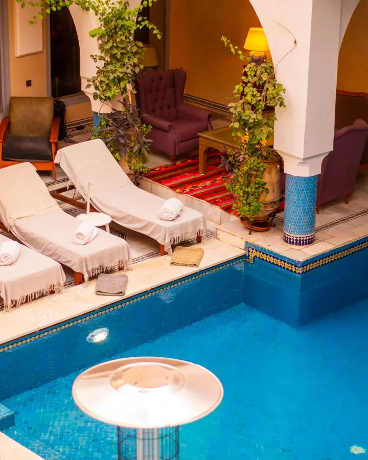 Elegant pool area with sunbeds and seating in Marrakesh, Morocco, ideal for relaxation.