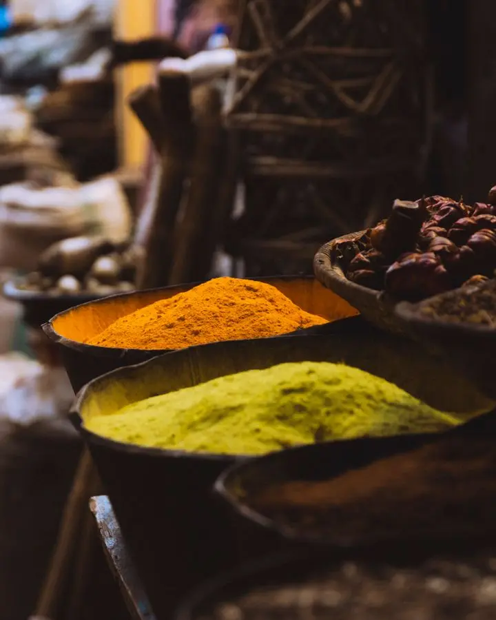 Colorful spices on display in a traditional market setting, emphasizing vibrant cultures.