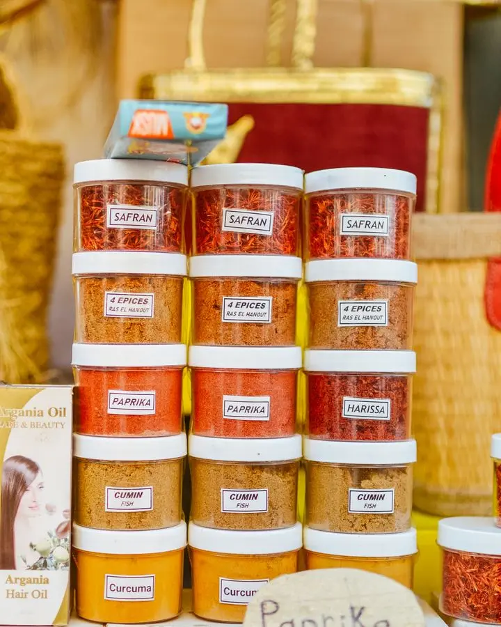 Colorful jars of various spices neatly displayed at a market stall.